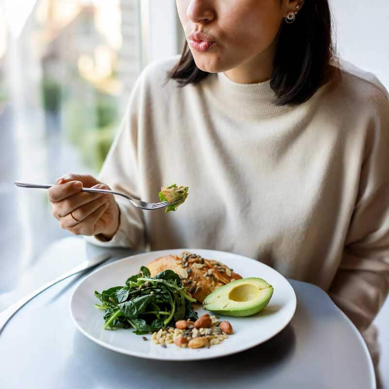 Eine Frau isst Omega-3-reiche Kost